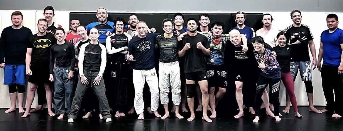 A group of Team Rumble grapplers and coaches together on the mats after training.