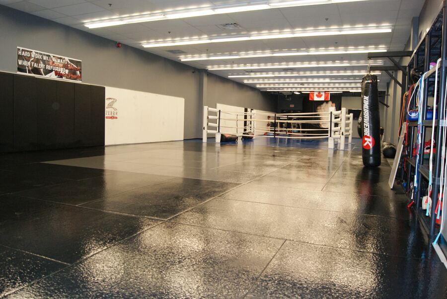 Inside the Rumble Martial Arts gym floor, showing the mats and boxing ring used for after-school games.
