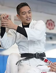 Master Steve Lin, Brazilian Jiu-Jitsu and Judo coach at Rumble Martial Arts, showing the red bar on his black belt.