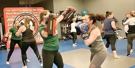 Women working pads together in a Battle Girl Bootcamp class in Keswick.